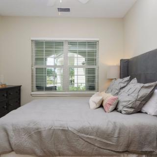 A cozy bedroom with a neatly made bed and a window letting in natural light.