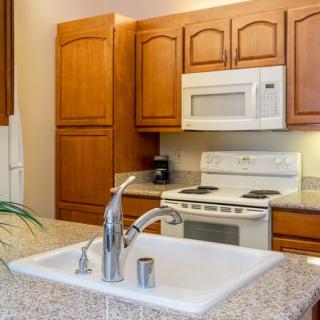 Modern kitchen with wooden cabinets and white appliances.