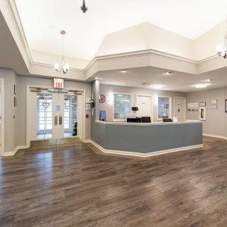 A modern reception area with a central desk and wooden flooring.