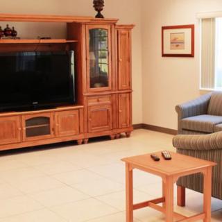 A cozy living room with a large entertainment center, television, and comfortable seating.