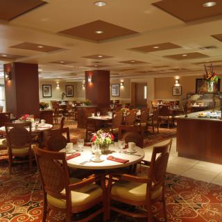 Cozy restaurant dining area with elegantly set tables and warm lighting.