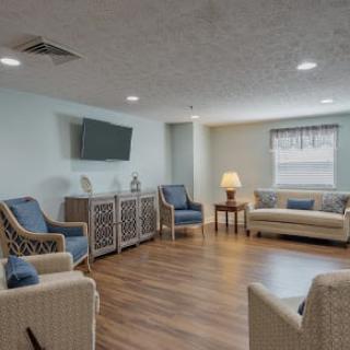 A cozy living room with seating area, a television, and warm lighting.
