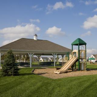 An outdoor playground with a slide and pavilion on a sunny day.