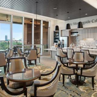 A modern restaurant interior featuring a well-lit dining area with elegant tables and chairs.