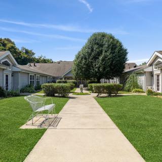 A peaceful suburban neighborhood with a central pathway and lush greenery.