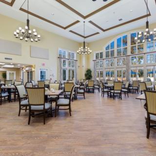 A spacious and elegant dining area with large windows and chandelier lighting.