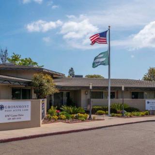 An office building with an American flag and a secondary flag flying at the entrance.