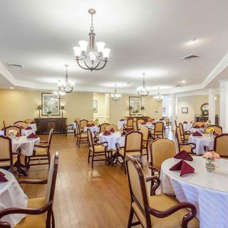 A spacious and elegant dining room with neatly arranged tables and chairs, adorned with chandeliers.