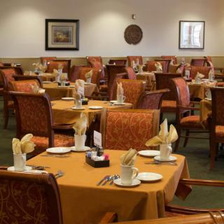 An empty restaurant dining area with neatly arranged tables and chairs.