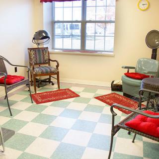 A cozy hair salon with vintage-style chairs and a checkered floor.