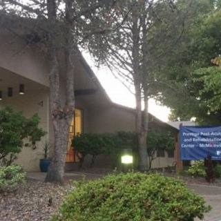 A church building with trees and an entrance sign.