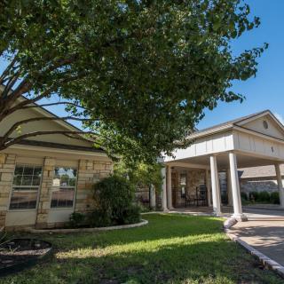 A suburban house with a spacious front yard and a large tree.