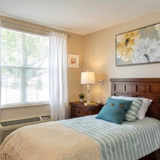 A cozy bedroom with a single bed and soft natural lighting.