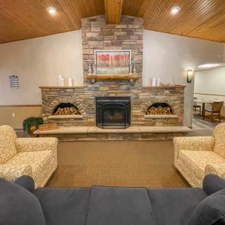 A cozy living room with a stone fireplace and comfortable seating.
