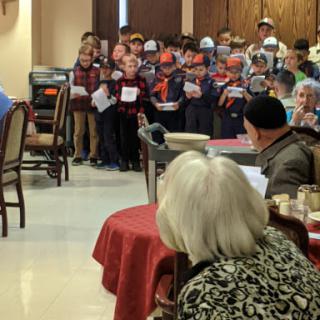 A group of children performing for an audience of seniors at a community event.