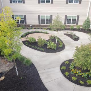 A well-designed garden pathway surrounded by lush greenery and flowerbeds.