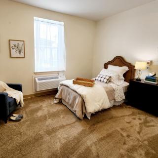A cozy bedroom with a single bed, warm lighting, and elegant decor.
