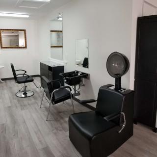 A modern hair salon interior with styling stations and chairs.