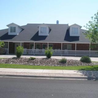 A suburban house with a large porch and landscaped front yard.