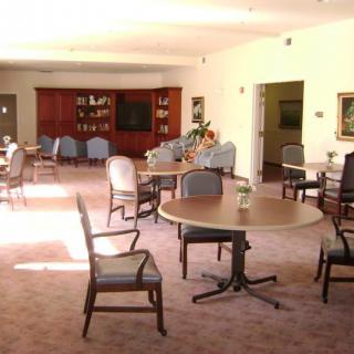 A spacious room with several tables and chairs, suitable for dining or meetings.