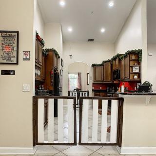 A cozy kitchen with wooden cabinets and a safety gate.
