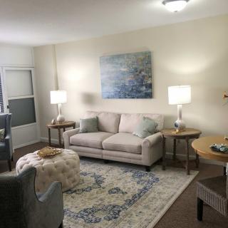 A cozy living room with a sofa, armchair, and stylish decor.