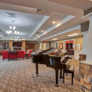 A spacious lounge area with a grand piano and comfortable seating arrangements.
