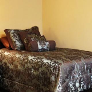 A neatly arranged bed with luxurious bedding and pillows.