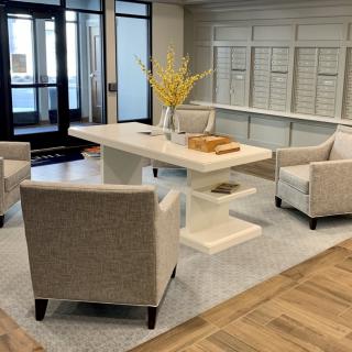 A modern lobby with comfortable seating and a central table.