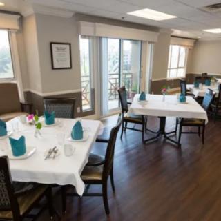 A neatly arranged dining room with tables set for a meal.