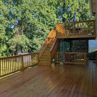 A spacious wooden deck surrounded by lush greenery.