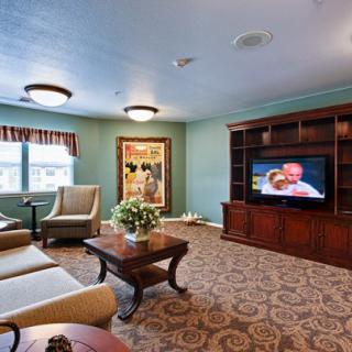 A cozy living room featuring comfortable seating, a television, and decorative artwork.