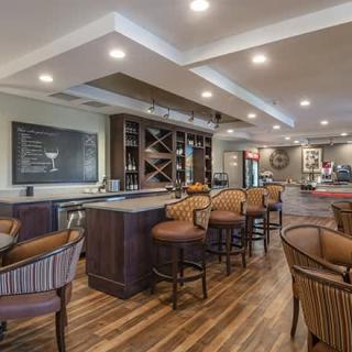 A cozy bar interior with wooden flooring and ample seating.