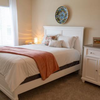 A cozy bedroom with a neatly made bed and elegant decor.