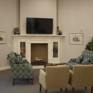 A cozy living room featuring a fireplace, television, and comfortable seating.