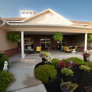 A welcoming exterior view of a building featuring a charming porch and vibrant landscaping.