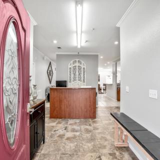 A modern reception area with a decorative entry door and seating.