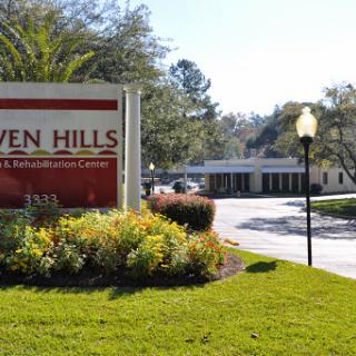 A welcoming entrance to Seven Hills, showcasing its vibrant landscaping and inviting atmosphere.