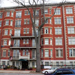 A red brick apartment building with multiple floors in an urban area.