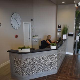 A modern reception area with a stylish desk and decorative plants.