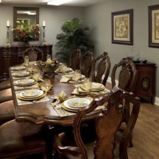 A beautifully set dining room table with elegant traditional furniture and decorative elements.