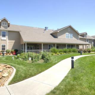 A large residential building with a well-maintained lawn and pathway.