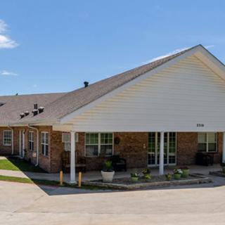 A suburban residential building with a sloped roof and a small porch area.