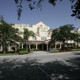 Front view of a building surrounded by trees and landscaping.