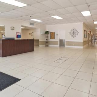 A spacious and clean hospital lobby with a reception desk and tiled floor.
