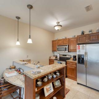 A modern kitchen with stainless steel appliances, wood cabinets, and a cozy breakfast bar.