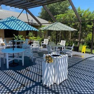 A sunny outdoor patio with umbrellas and seating arrangements.