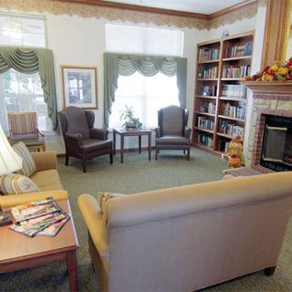 A cozy living room with comfortable seating, bookshelves, and a fireplace.