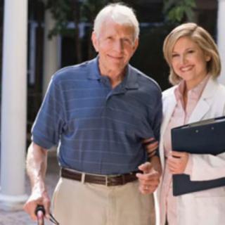 An elderly man receiving assistance from a healthcare professional outdoors.