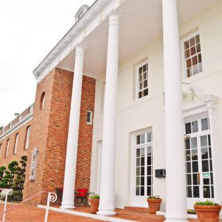 A building with classic architecture featuring white columns and a brick facade.